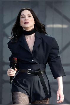 a woman in black outfit holding a microphone