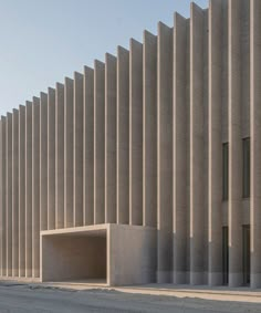 the building is made out of concrete and has vertical lines on each side that give it an architectural look