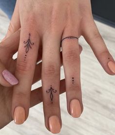 two fingers with small tattoos on them