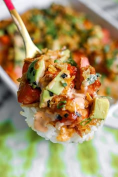 a spoon full of food on top of rice