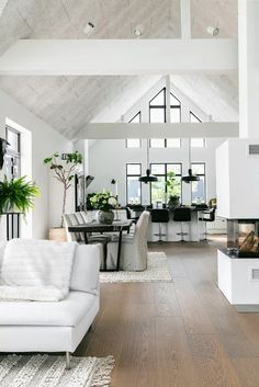 a living room filled with furniture and a fire place next to a white couch on top of a hard wood floor