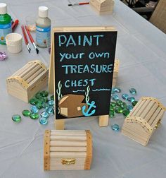 there is a chalkboard sign on the table with other items around it and paint