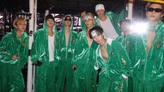 a group of people dressed in green outfits