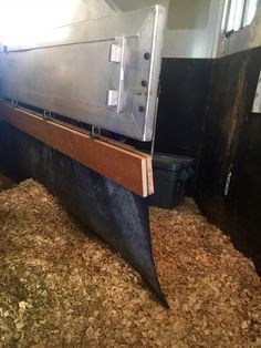 the inside of a horse barn with hay on the floor