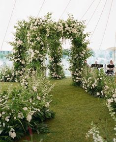 an outdoor ceremony with white flowers and greenery