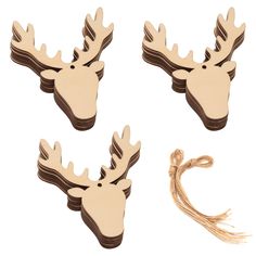 three wooden moose head charms with tassels on white background, one is brown and the other is beige