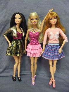 three barbie dolls standing next to each other