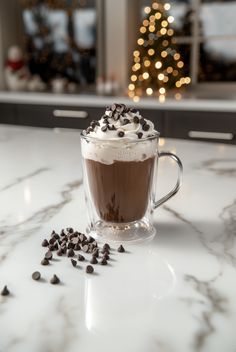 a cup of hot chocolate with whipped cream and chocolate chips