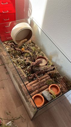 a pile of wood sitting on top of a wooden floor next to a red dresser