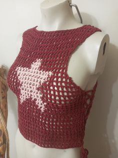 a white mannequin wearing a red crochet top with stars on it