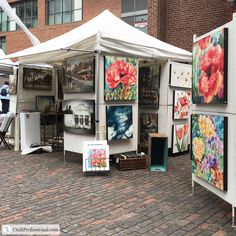 an outdoor art market with paintings on display