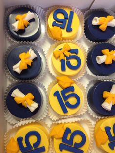 cupcakes decorated with yellow and blue icing in a box for an eighteen year old