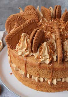 a close up of a cake on a plate with frosting and chocolate cookies around it