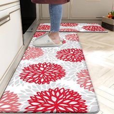 a woman is standing on the kitchen floor with her feet up and cleaning the area