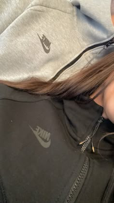 a woman with long hair wearing a nike hoodie