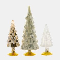 three glass christmas trees on yellow bases with white background, one is clear and the other is gold