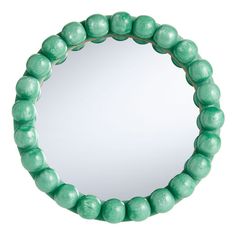 a round mirror with green beads around it