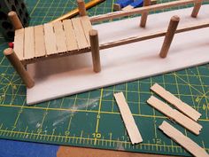 a wooden bench made out of popsicle sticks sitting on top of a cutting board