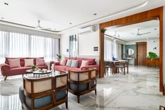 a living room filled with furniture and a large mirror on the wall above it's doorway