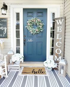 a blue front door with a welcome sign and wreath