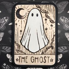 a wooden card with a ghost on it