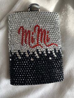 a black, white and red purse with the word mell written in red on it