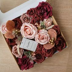 a box filled with flowers on top of a wooden table