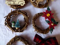 four christmas wreaths are arranged on a white sheet with ornaments in the shape of cars and snowmen