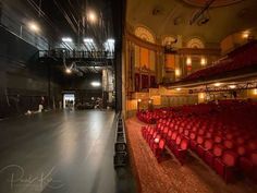 an empty auditorium with red seats and lights