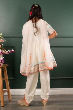 Off white three fourth sleeves kurta with mirror work embroidery on border and pom pom detailing. Paired with pom pom detailing petal hem dhoti pant and dupatta.
Components: 3
Pattern: Embroidered
Type Of Work: Mirror Work, Pom Pom
Neckline: Round
Sleeve Type: Three Fourth
Fabric: Pure Chanderi Silk, Dola Silk, Organza; Lining: Mul Mul Cotton
Color: Off White
Other Details: 
Closure: 
Kurta: Back zip
Dhoti pant: Elasticated
Note: The hair accessory and potli bag shown in the image is not for sal Mirror Work Kurta, Potli Bag, Dhoti Pants, Girl Online, Silk Organza, Mirror Work, Pant Set, Embroidered Silk, Aza Fashion