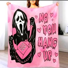 a woman holding up a pink and black towel with a ghost on it's back