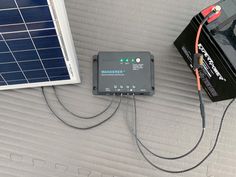 the solar panel is plugged in and connected to an electronic device with two wires running through it