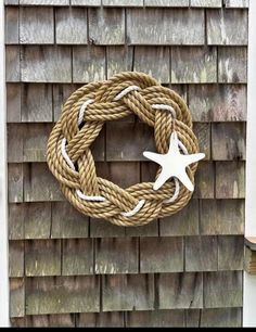 a rope wreath hanging on the side of a wooden wall next to a starfish