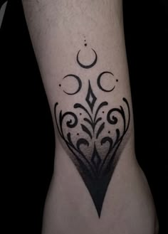 a black and white photo of a tattoo on the leg, with an ornamental design