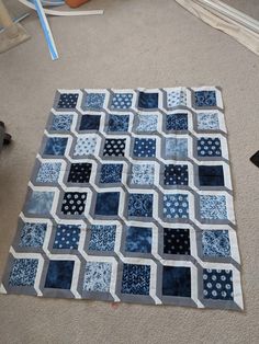 a blue and white patchwork area rug on the floor in a room with carpeting