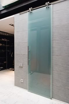 a walk in closet with glass sliding doors