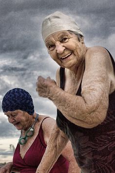 an old woman is running with another older woman in front of her on a cloudy day