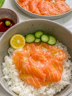 two bowls filled with rice, cucumbers and salmon