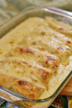 a casserole dish with cheese and meat in it sitting on a colorful cloth