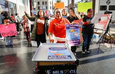 a group of people holding signs and standing around