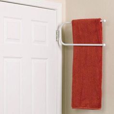 an orange towel is hanging on the wall next to a white door and a red towel rack