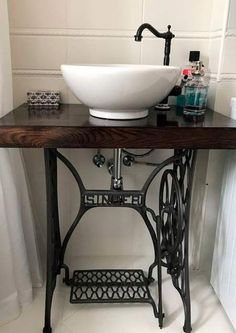 an antique sewing table with a sink and faucet in the center is shown