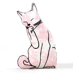 a pink and white cat sitting on the ground with its paw in it's mouth