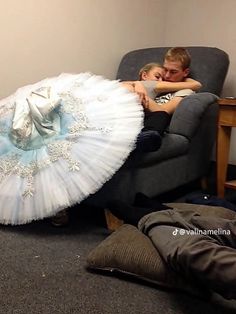 a man and woman laying on a couch with an umbrella