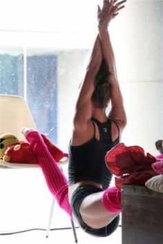 a woman is doing yoga in front of a window