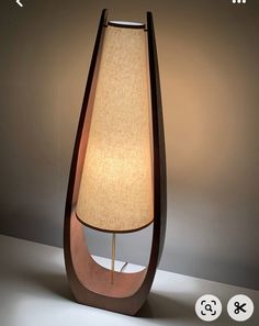 a lamp that is sitting on top of a table next to a light fixture with a beige shade