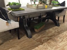 a dining room table with two chairs and a bowl of vegetables on top of it