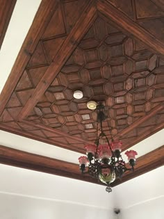 a chandelier hanging from the ceiling in a room with white walls and wood paneling