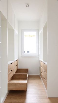 an empty room with wooden steps leading up to the window and white cabinets on either side