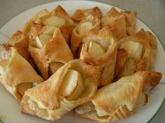 a white plate topped with apple turnovers on top of a table